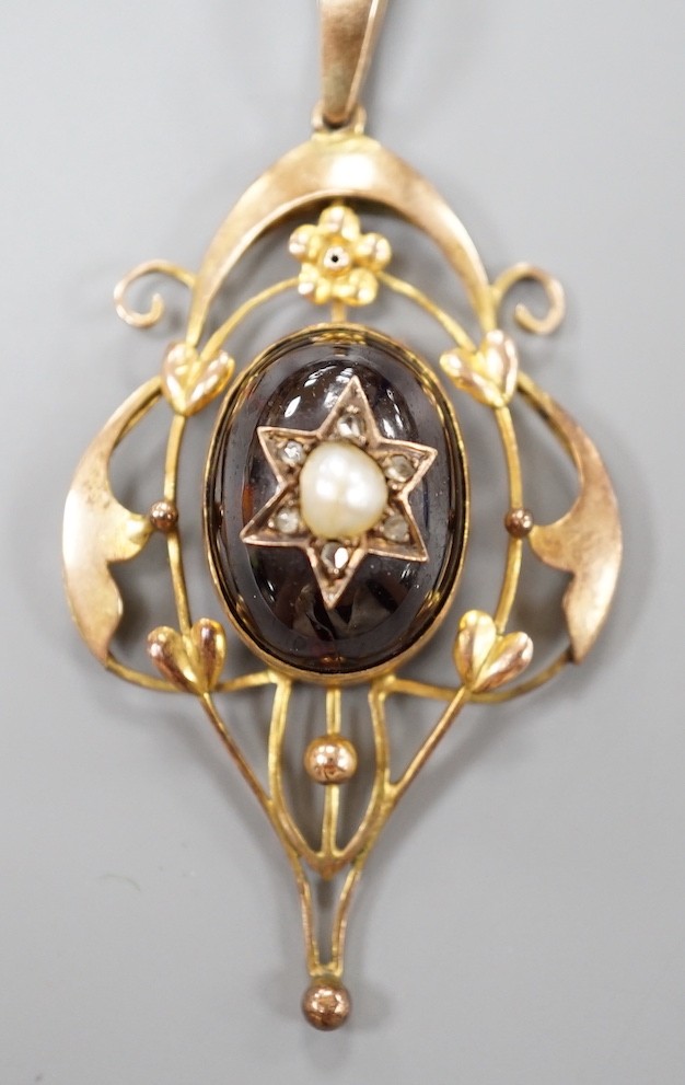 An Edwardian Art Nouveau 9ct, garnet, split pearl and diamond set pendant, overall 57mm, gross weight 6.8 grams.